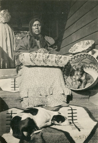 Native American basket maker Dolores Francesca on porch of the Barker House in Banning, California displaying some of her baskets