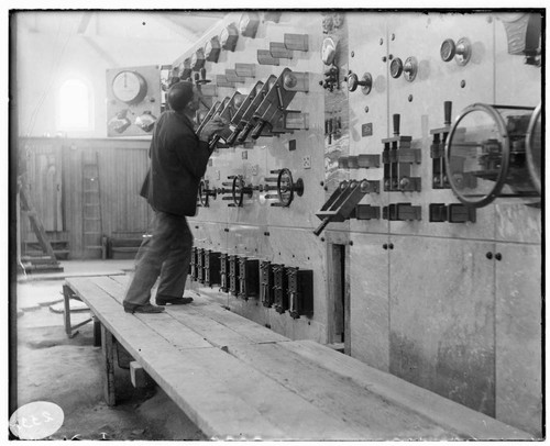 A man conducting a first aid demonstration at the switchboard of Mill Creek #3 Hydro Plant