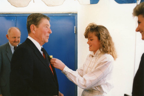 A boutonniere being pinned on President Reagan
