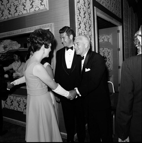 UCSD Chancellor William J. (William James) McGill shaking hands with a lady in the receiving line at the UCSD Faculty Ball. April 25, 1970