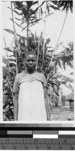 Girl standing outside in front of a tree, Africa, August 1948