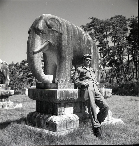 Soldier posing with elephant sculpture