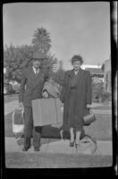 Wayne West and Maud West stand on the walkway in front of H. H. West's home and pose with their luggage, Los Angeles, 1944