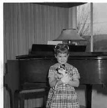 Girl standing next to a piano