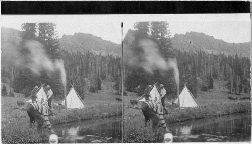 Early morning breakfast - before beginning the hunt - head of Horse Creek, Montana. Hunting [Three men and a dog in a small camp by the river with either cows or probably horses and forest in the background.]