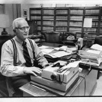 Justice Bertram D. Janes, sitting at the desk in his office, typing. He was about to retire
