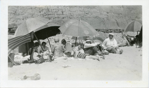 Beach-goers under umbrellas at Santa Monica Canyon beach, 1928