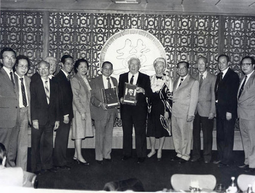 Poy Wong (center) receiving an award from a supervisor