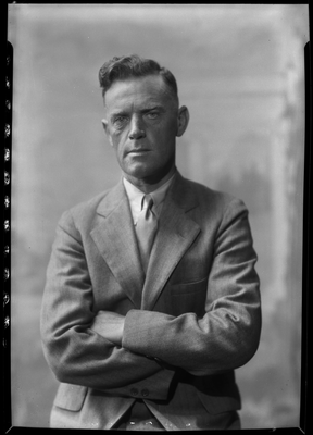 Portrait of man in suit sitting with arms crossed