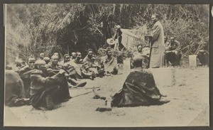 African preacher standing in front of Maasai men, Tanzania