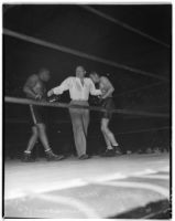 Referee Max Baer stands between George Godfrey and Hank Hankinson during a boxing match at Olympic Auditorium, Los Angeles, August 10, 1937