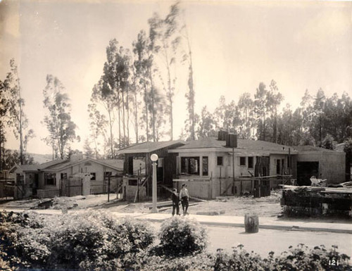 [Two unidentified boys skating in front of unfinished houses in Westwood Park]