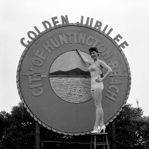 Ann Gardner at the Huntington Beach golden jubilee sign, June 1954