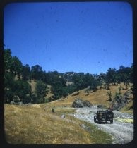Jeep parked on gravel at base of foothills
