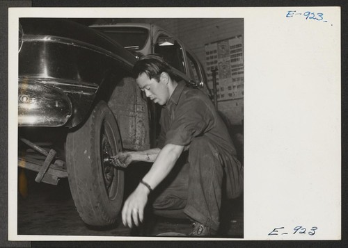 Jim Canda, a former west coast garage operator who spent several months in the Granada Relocation Center, inspects brake drums on his present job as night manager of the Master Service Garage in Denver. Photographer: Parker, Tom Denver, Colorado