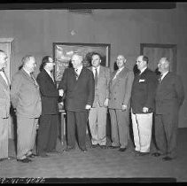 Eight men standing in an office