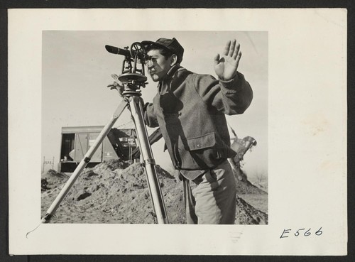 A young Nisei operates a surveying instrument in laying out the grounds for administrative quarters. Photographer: Parker, Tom Amache, Colorado