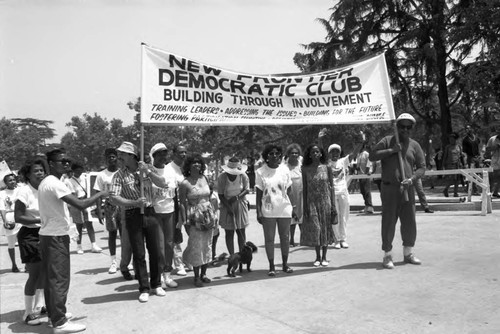 Members of the Frontier Democratic Club holding a banner during the Black Family Reunion, Los Angeles, 1989