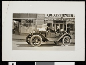 Two men in an automobile parked in front of the Great Western Power Company, ca.1920
