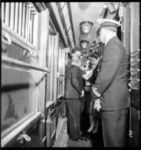 [Men and woman with United States naval officers on train]