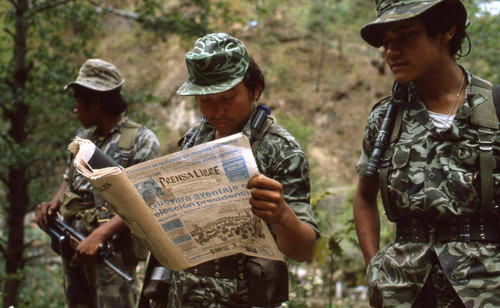 Soldier reads Prensa Libre newspaper while on patrol, Chichicastenango, 1982