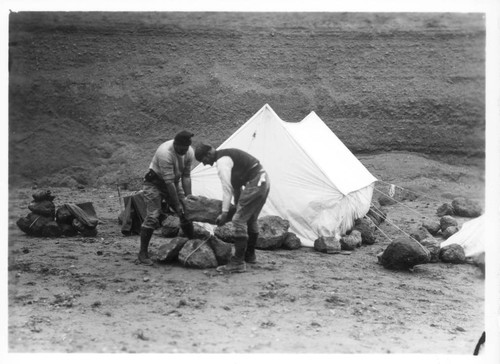 Putting rocks around tent as protection, H-8336