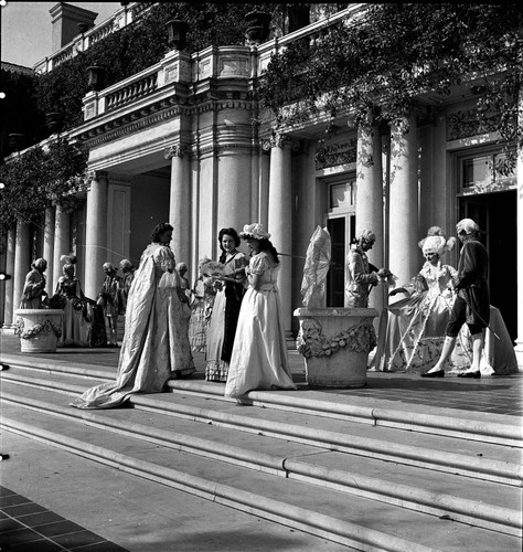 Twelve people in period costume on the terrace steps by the south entrance of the Huntington residence