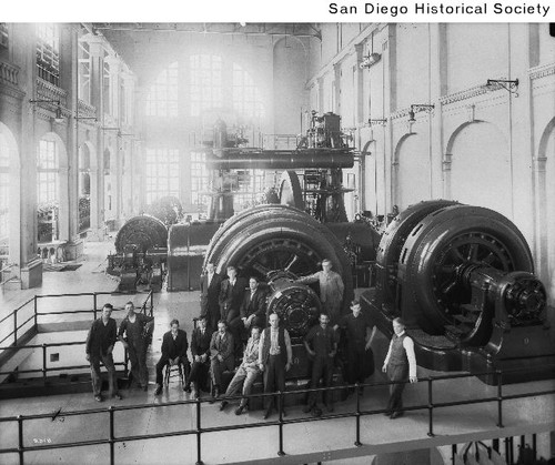 Men standing near two generators inside San Diego Gas & Electric Company's Station B