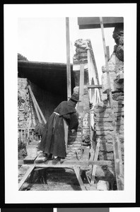 Monk on scaffolding during the reconstruction of the Mission San Juan Capistrano under Reverend John O'Sullivan