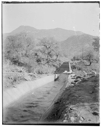 Junction of Kaweah canal in foreground and a long section of flume flowing into the distance