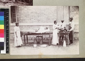 Midwife weighing new born child, Madagascar, ca. 1910