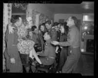 Actresses Betty Hutton and Mona Freeman at piano singing with United States servicemen, 1945