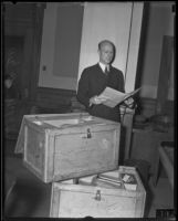William H. Neblett, attorney, in court holding documents contained in 2 shipping boxes, Los Angeles, circa 1935