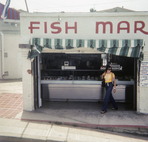 Woman in front of a fish market on Santa Monica Pier