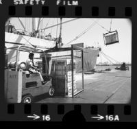 Longshoreman loading boxes of Sunkist Lemons onto ship in Long Beach, Calif., 1975