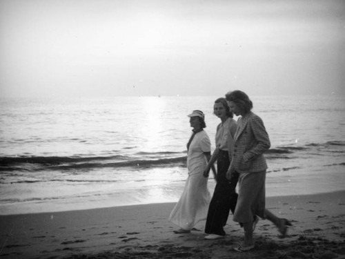 Three women walking by the water's edge