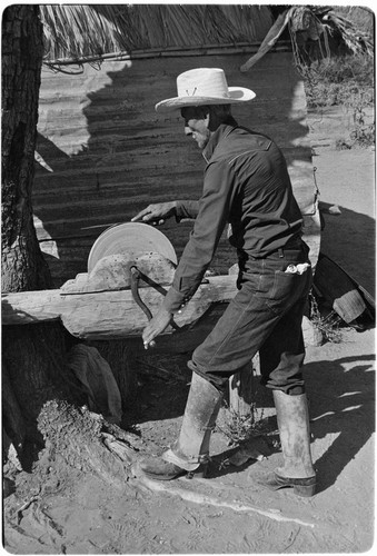 Rancher sharpening machete in Misión Guadalupe area