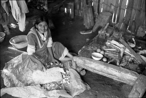 Refugee woman scrapes a block of lime stone, Chiapas, 1983