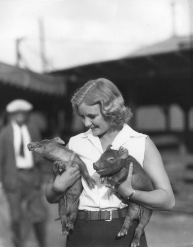 Woman holding pigs
