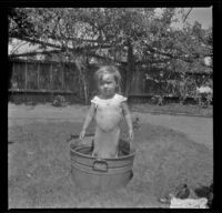 Ambrose Cline stands in a tub in the West's backyard, Los Angeles, about 1916
