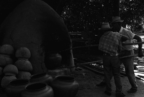Men working the clay oven, La Chamba, Colombia, 1975