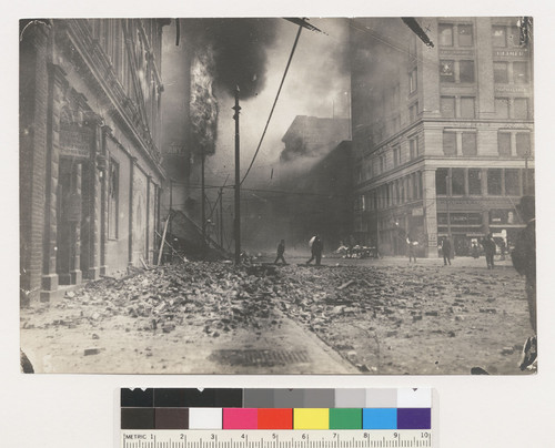 Third St. at Mission. [People in street among rubble; fire burning in distance.]