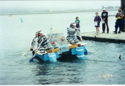 Bodega Marine Laboratory float, 'The Rock,' with crew paddling float at the Fisherman's Festival in Bodega Bay, 1997