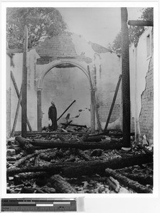 Father Jarreau standing in the ruins of a chapel, China, 1914