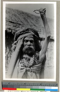 Hindu man with arm raised to seek religious merit, Vārānasi , India, ca. 1920
