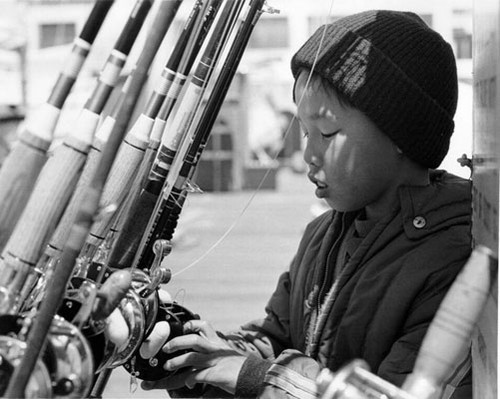 [Young boy with fishing rods at Yacht Harbor, Marina District]
