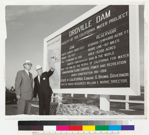 Edmund G. Brown in front of Oroville Dam project sign