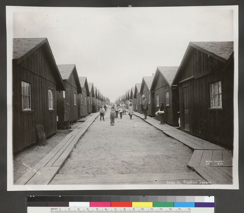 Camp 13, Franklin Square. [Refugee children posing between rows of cottages.]