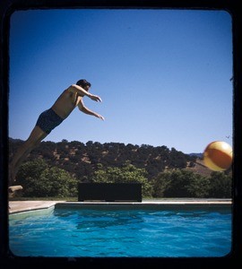 Milner family party, man jumping off diving board into a pool, Ojai, Calif., ca. 1950s