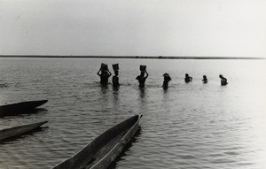 A group fishing in the river with fish traps